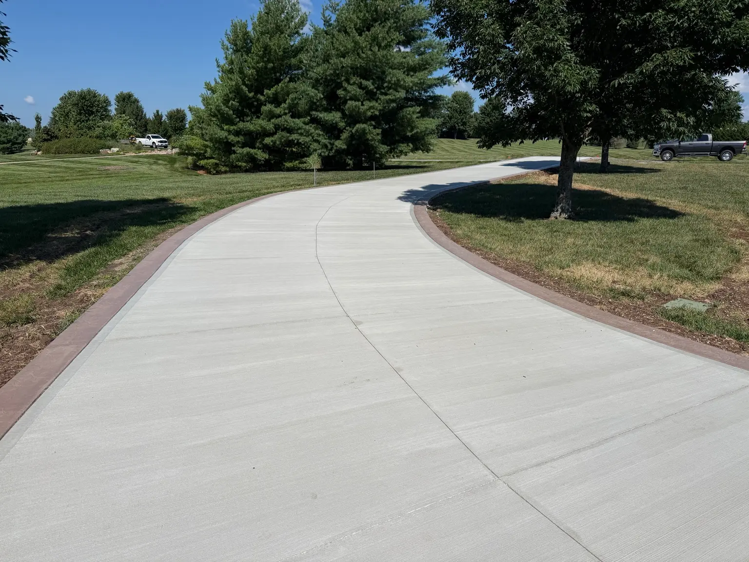 Finished curved concrete driveway with decoratvie borders by B&P Concrete