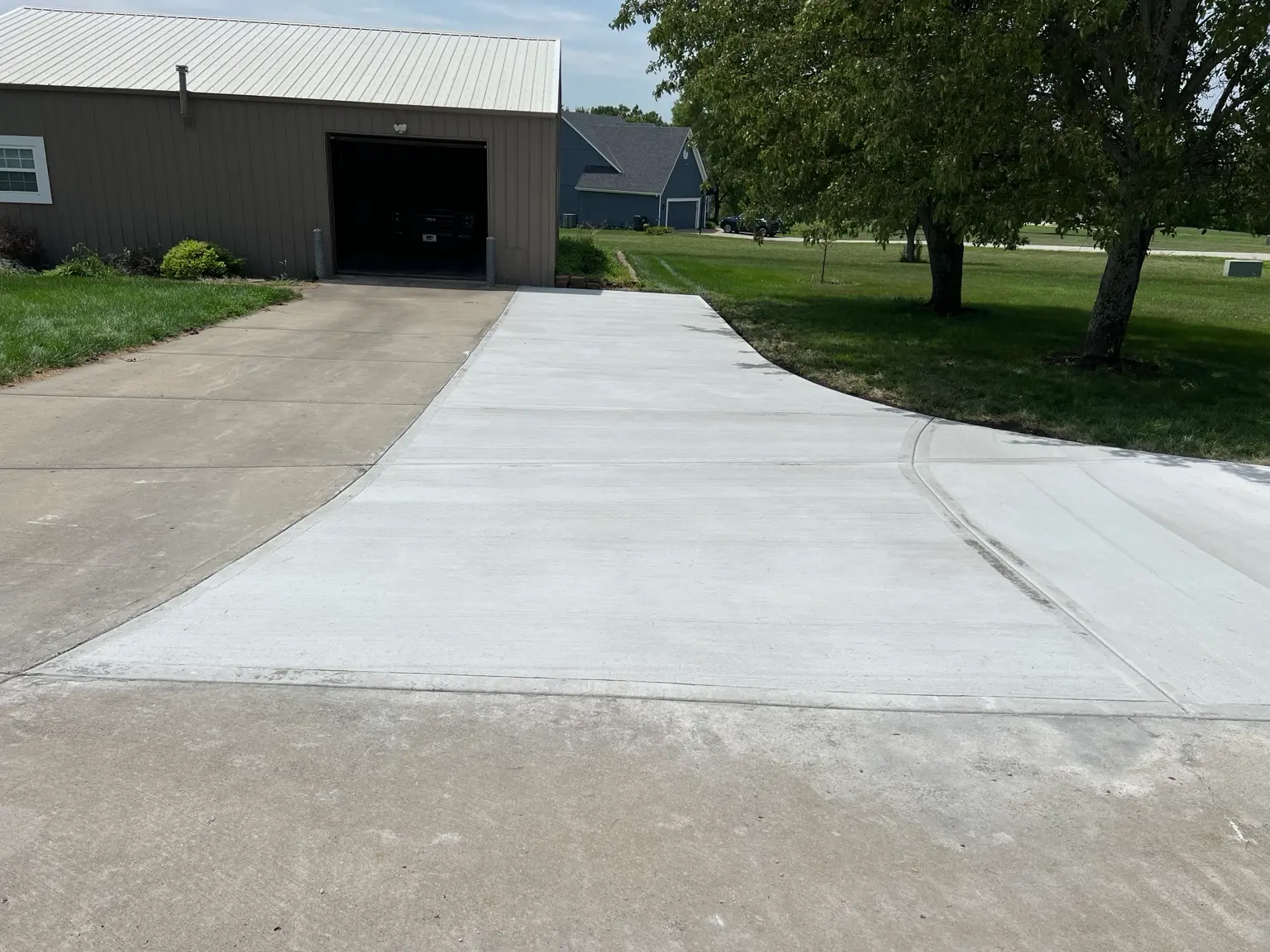 New concrete driveway extension beside existing concrete leading to a detached garage