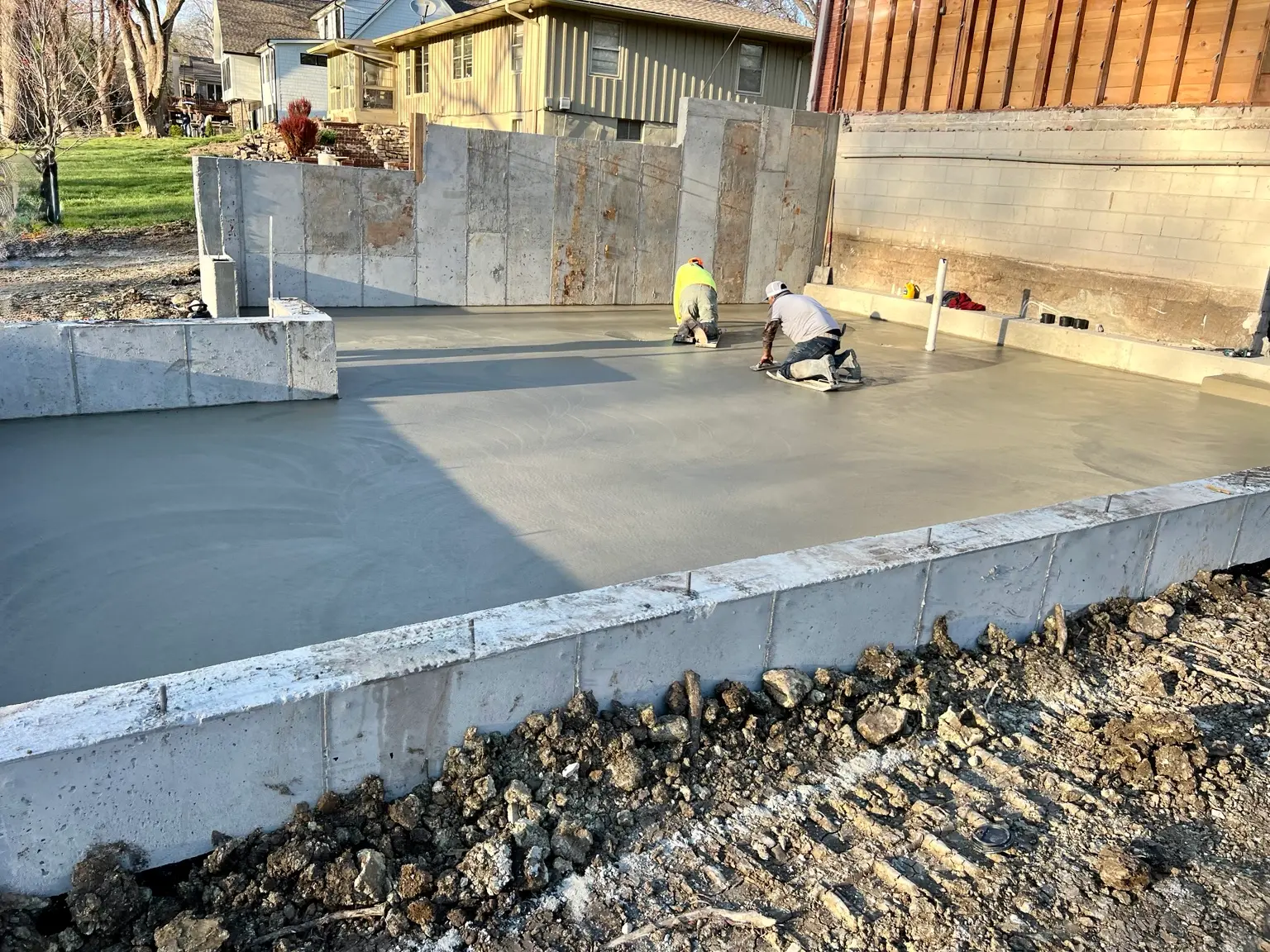 B&P Concrete crew finishing a concrete slab inside poured foundation walls