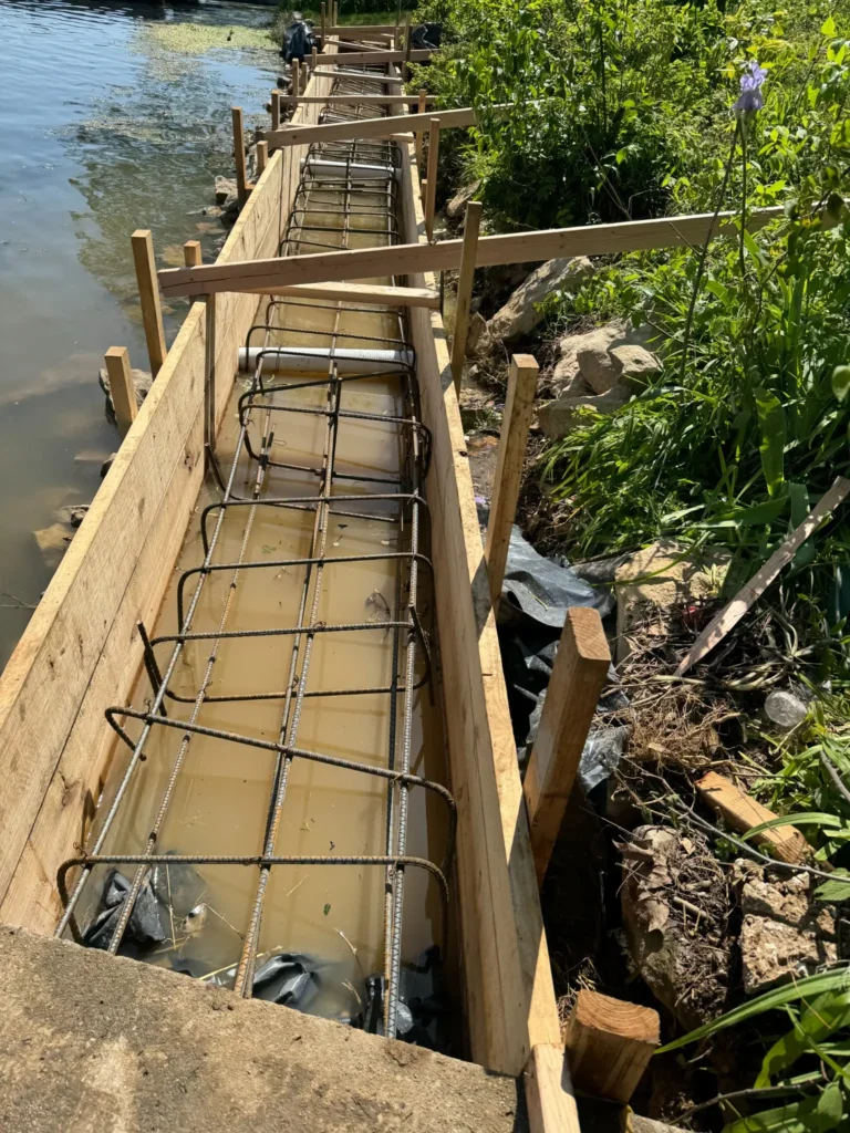 Concrete seawall forms and steel reinforcement installed along a residential shoreline in Kansas City
