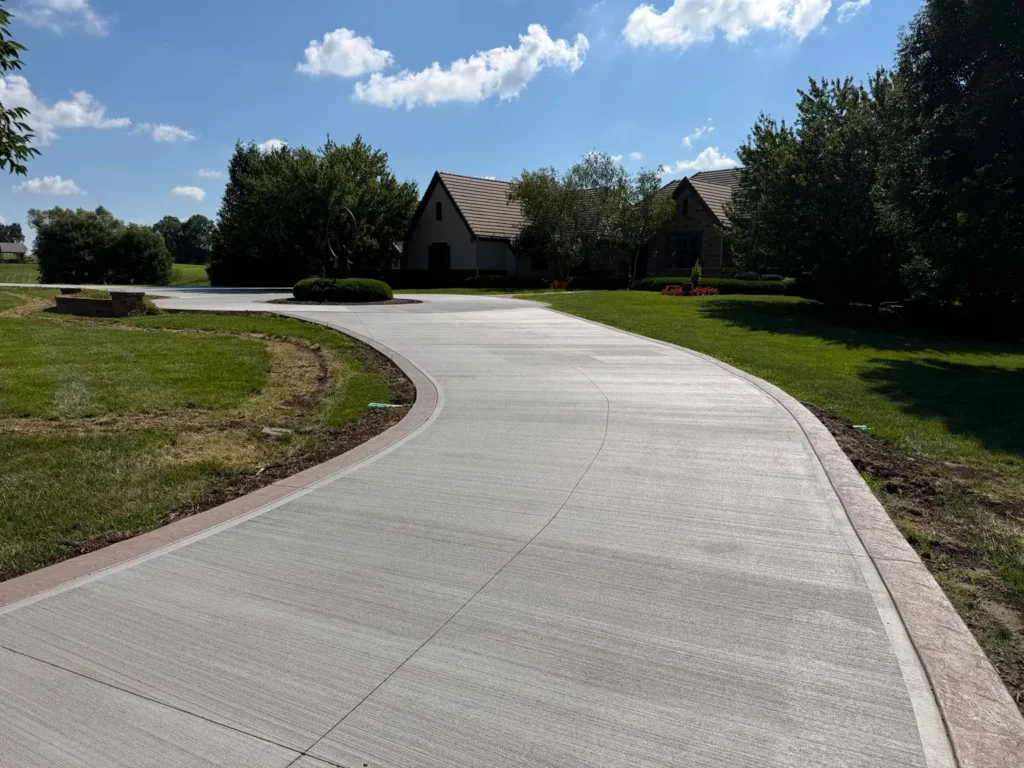 Finished curved concrete driveway with decorative border installed by B&P Concrete