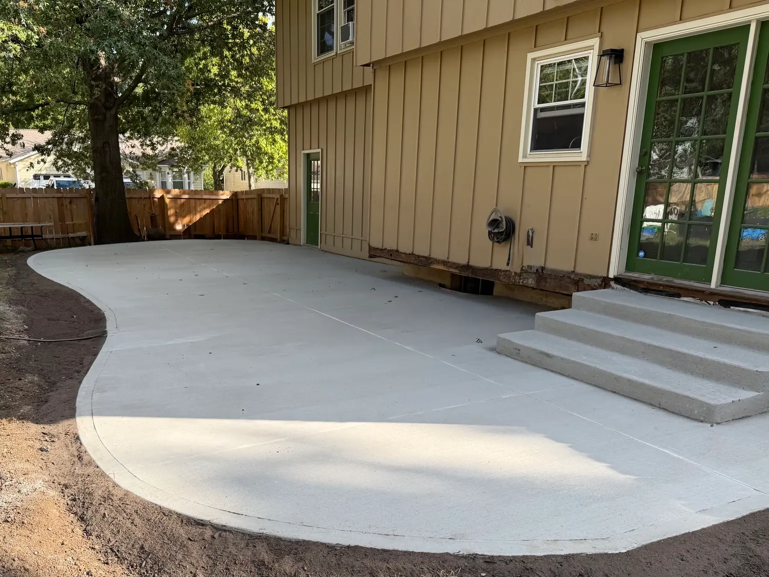 Curved concrete patio with steps installed by B&P Concrete in the Kansas City area