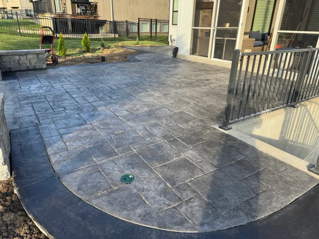 Dark gray stamped concrete patio with decorative border installed by B&P Concrete in the Kansas City area