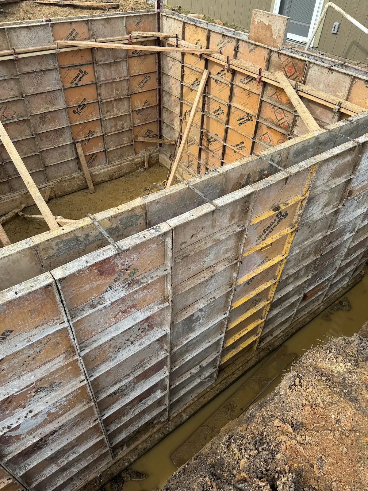 Concrete forms set up for poured foundation walls on a residential project
