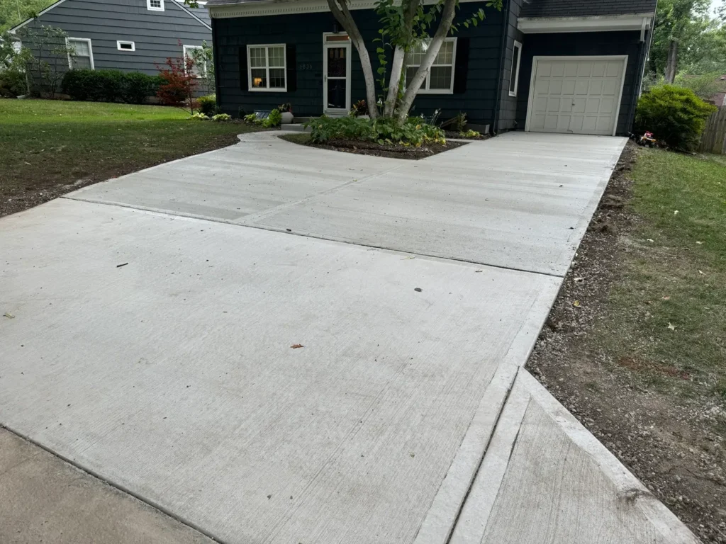 Finished concrete driveway installation in front of a residential home