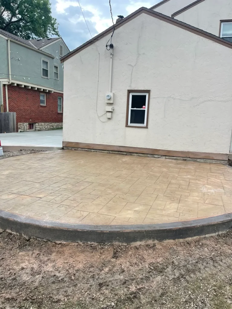 Tan stamped concrete patio with curved border installed by B&P Concrete in the Kansas City area