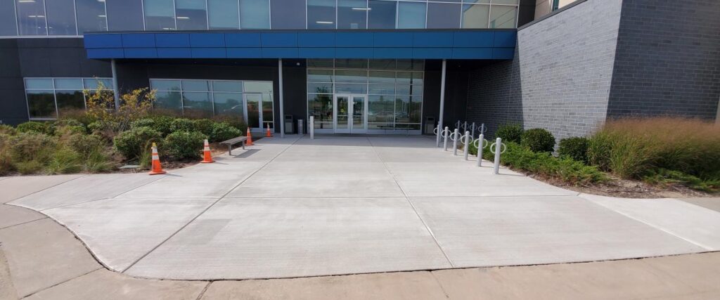 Completed concrete sidewalk and entrance outside a commercial building