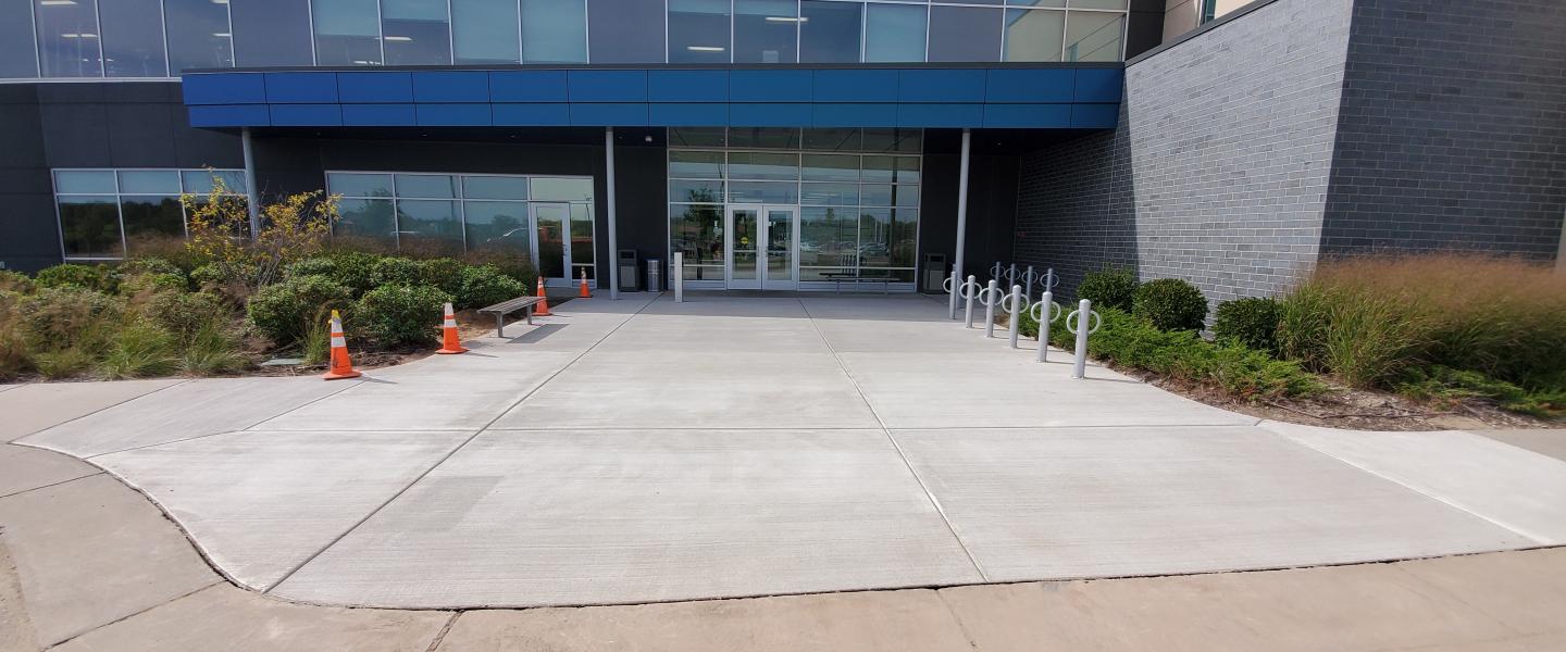 Completed concrete sidewalk and entrance outside a commercial building